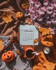 Warm flat lay featuring a November calendar with pumpkins, leaves, and fall colors.